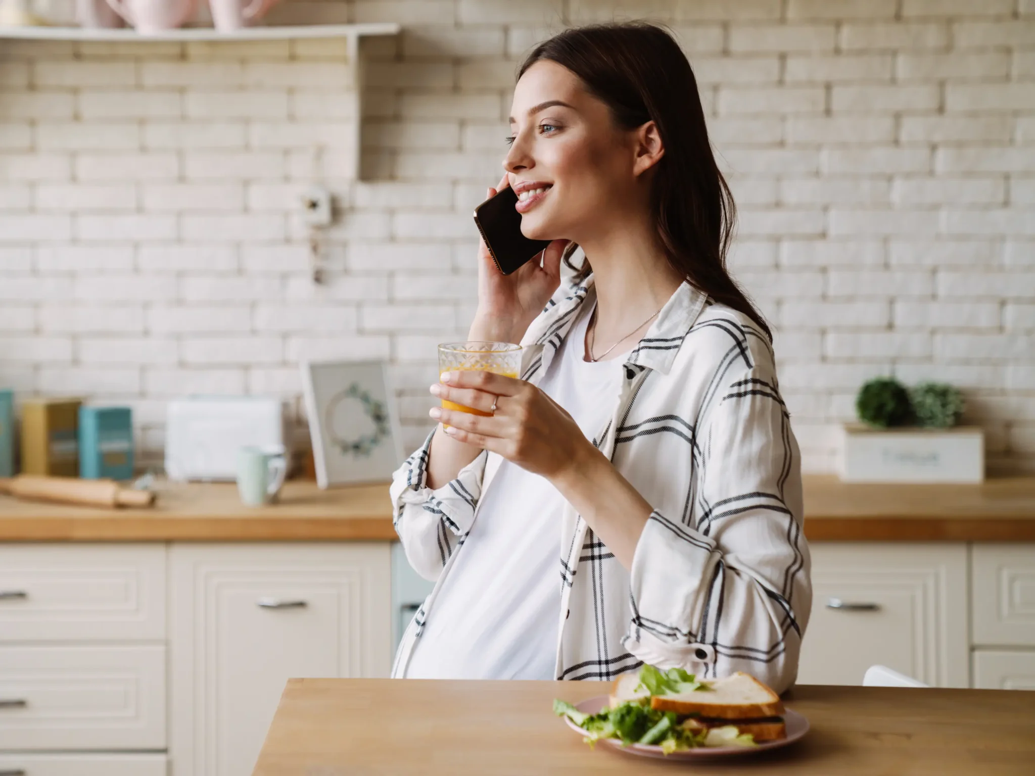 donna incinta che mangia un toast, è importante consumare 5 6 pasti al giorno in gravidanza