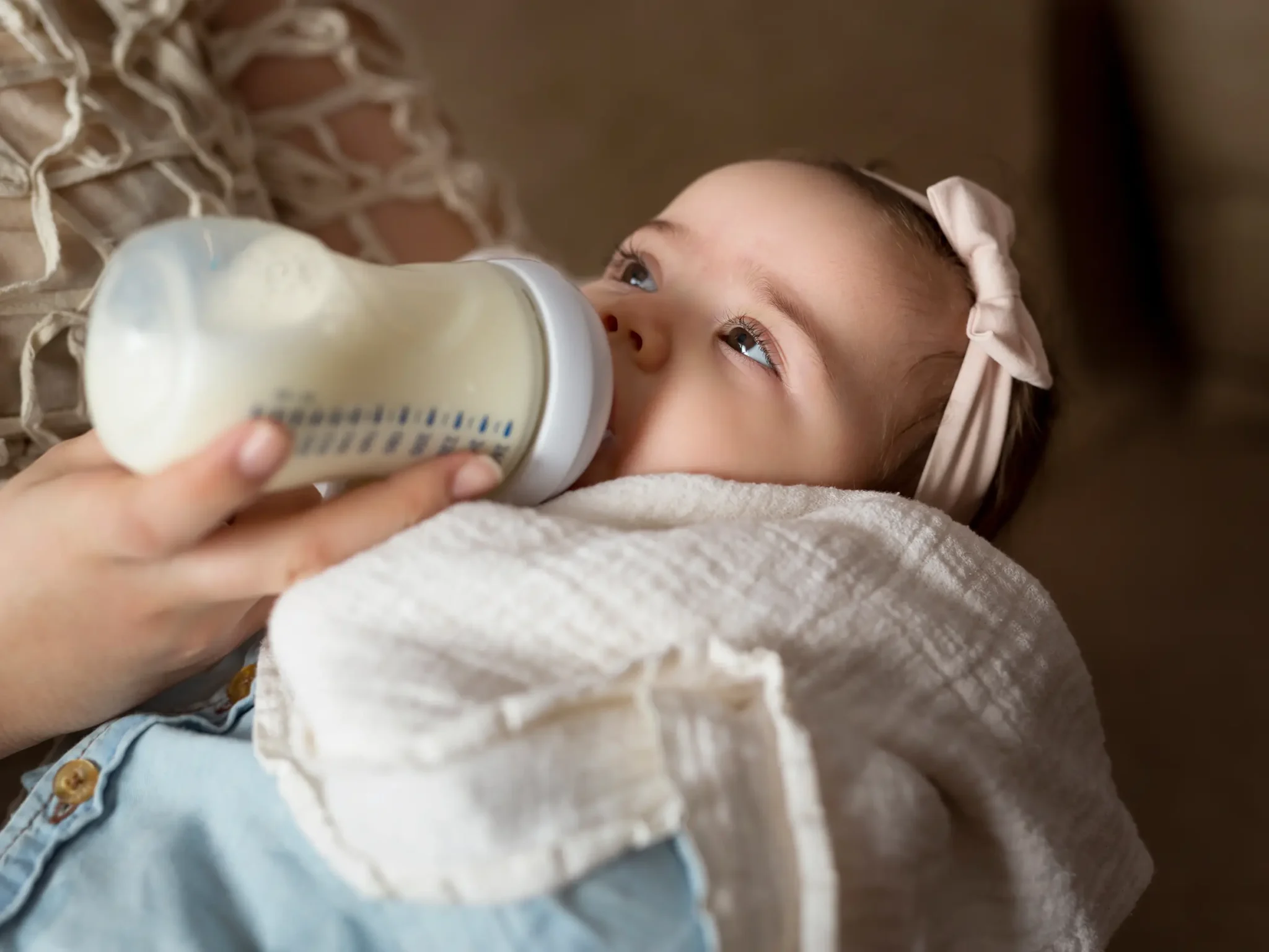 bambina che beve latte artificiale, la differenza tra galattosemia e intolleranza al lattosio
