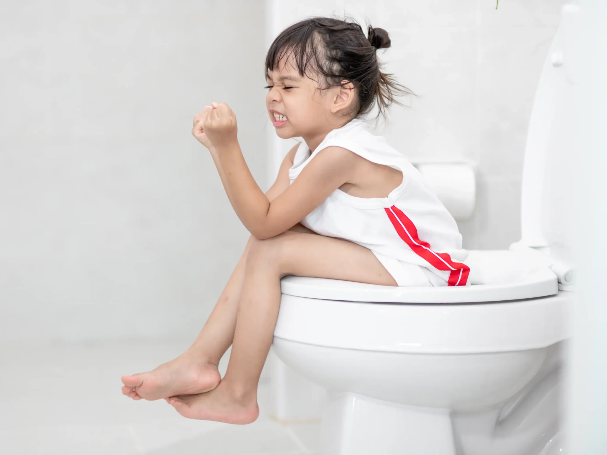 immagine di una bambina in bagno perché soffre di stitichezza