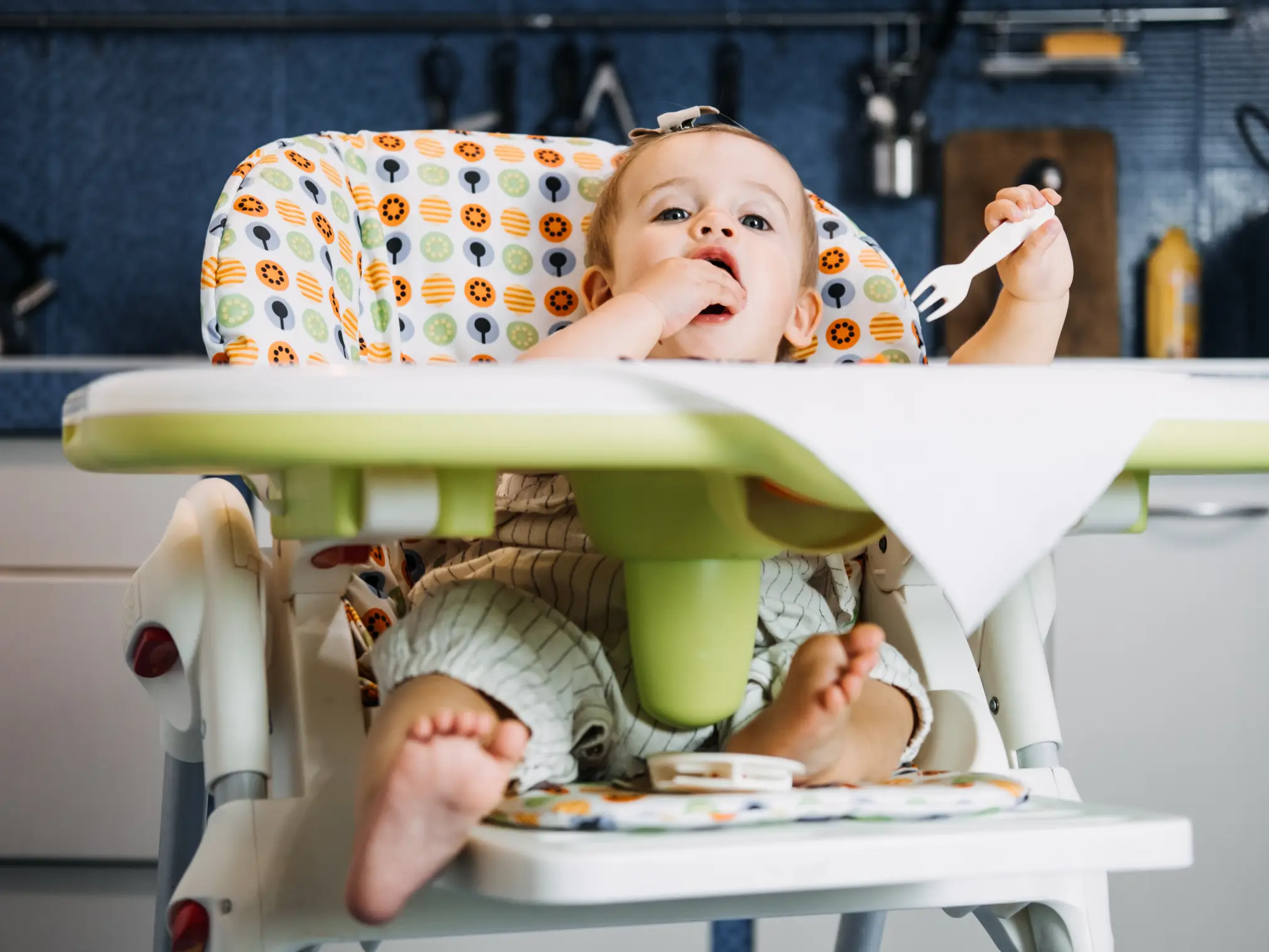 bambina che mangia autonomamente del cibo solido, lo svezzamento a 6 mesi