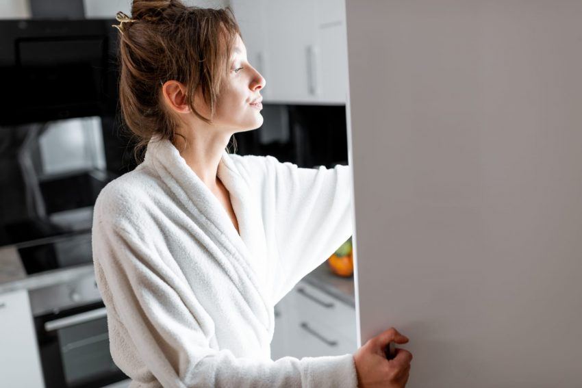 Fame emotiva donna prende cibo da frigo