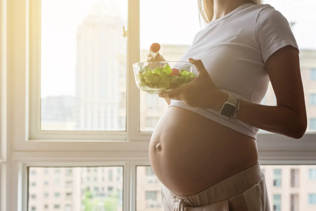 l'immagine rappresenta una donna in gravidanza che assume alimenti vegetali contro il colesterolo