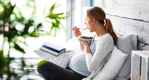 l'immagine rappresenta una donna in gravidanza che mangia della frutta