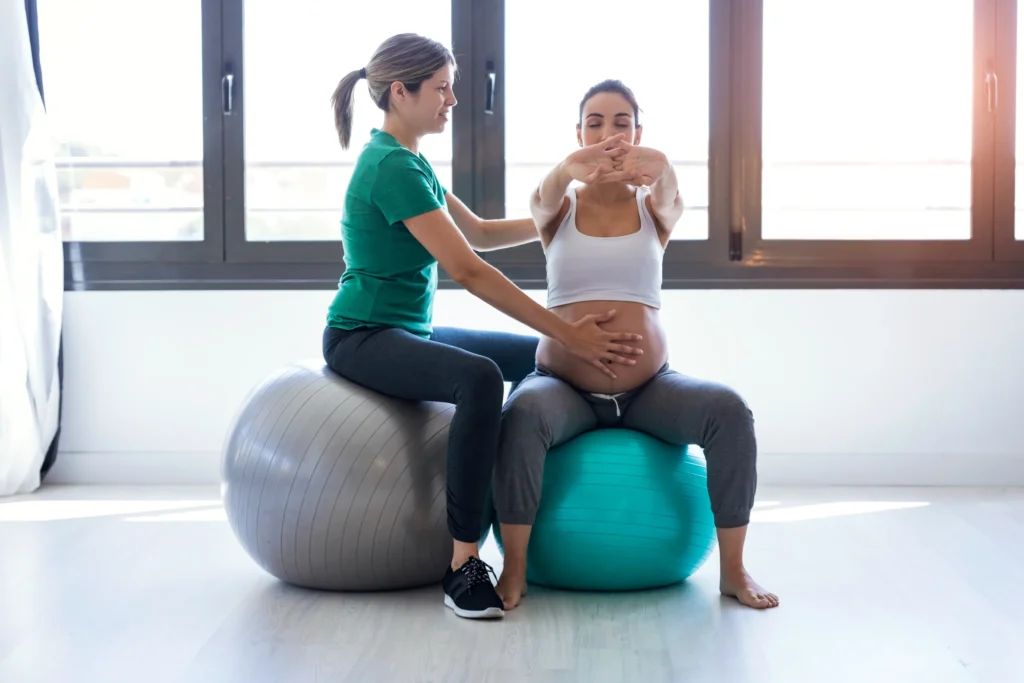 la foto rappresenta una donna in gravidanza che fa pilates con l'istruttrice