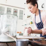 donna che impasta con acqua frizzante e bicarbonato per sostituire il lievito se si soffre di intolleranza al lievito