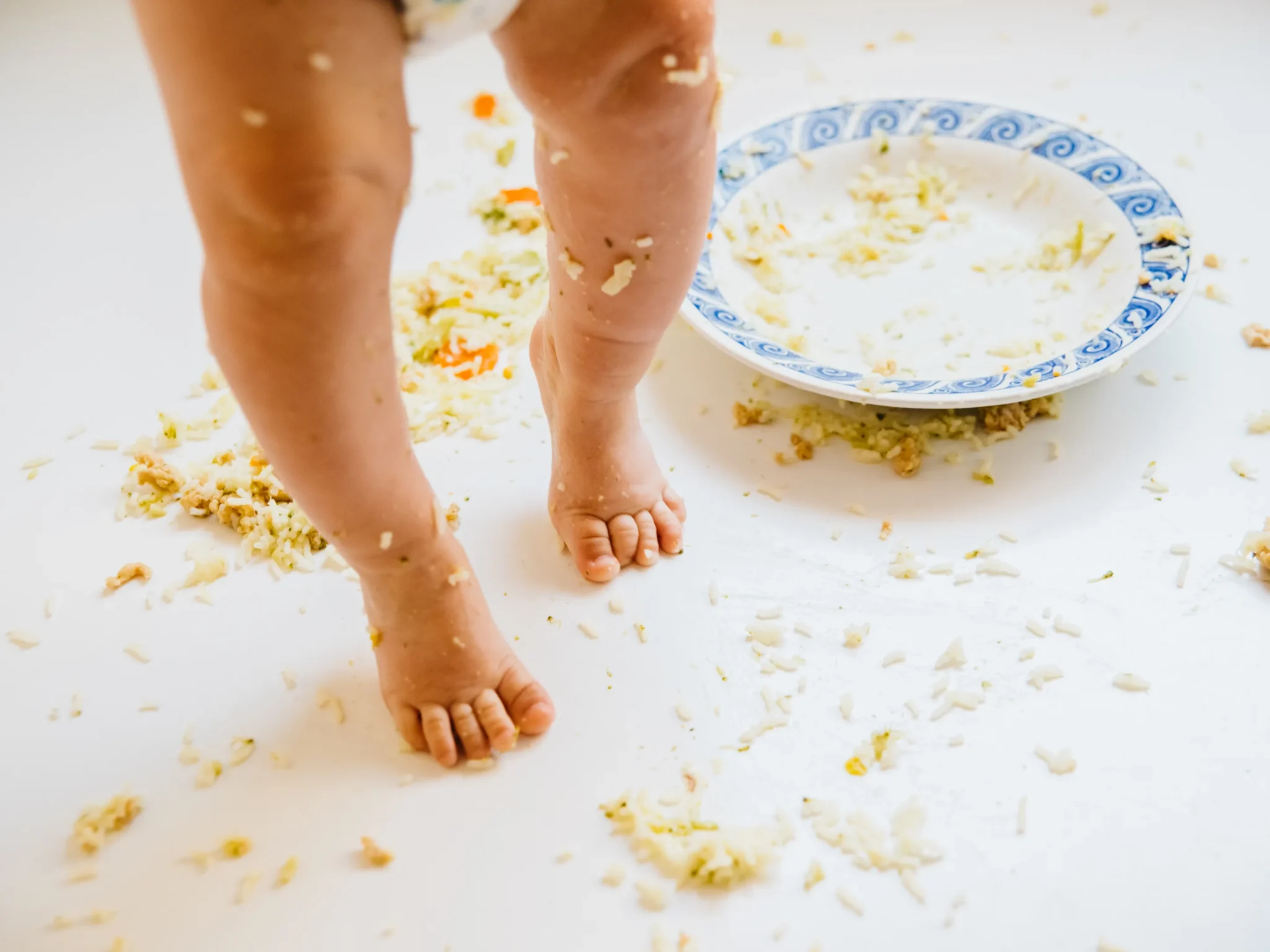 bambino con piatto rovesciato durante lo svezzamento, la chiave per lo svezzamento del neonato è pazienza calma e gioco