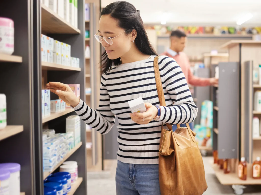 donna che controlla le etichette al supermercato, controllare la presenza di allergeni sull'etichetta dei prodotti se si soffre di cross-reattività
