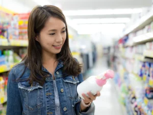 donna che controlla etichetta del sapone al supermercato, importante per allergia al nichel