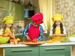 bambini che tagliano frutta e verdura, importanza di consumare frutta e verdura ad ogni pasto per alimentazione in infanzia