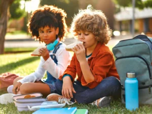 bambini che mangiano un panino, scegliere cibi ricchi di carboidrati per alimentazione in infanzia per apporto di energie
