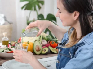 donna che beve e assume frutta e verdura ricca di acqua, è importante idratarsi molto se si soffre di morbo di crohn