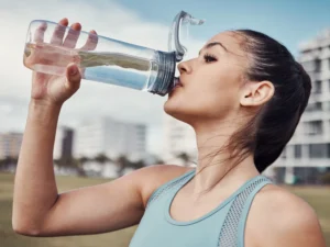 ragazza che beve durante l'allenamento, importanza dell'idratazione con colon irritabile